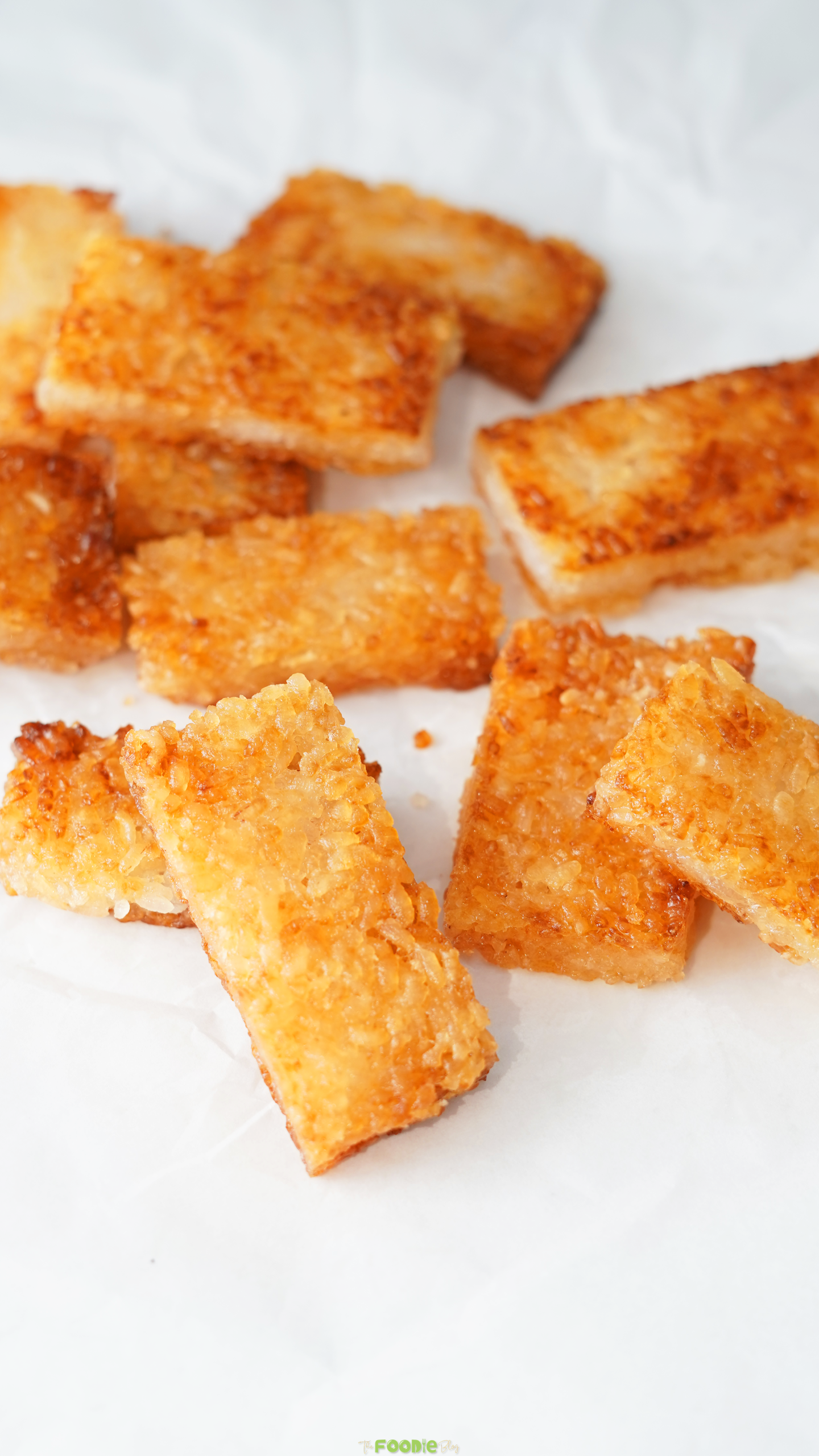 Golden pan-fried crispy rice rectangles cooling on parchment paper