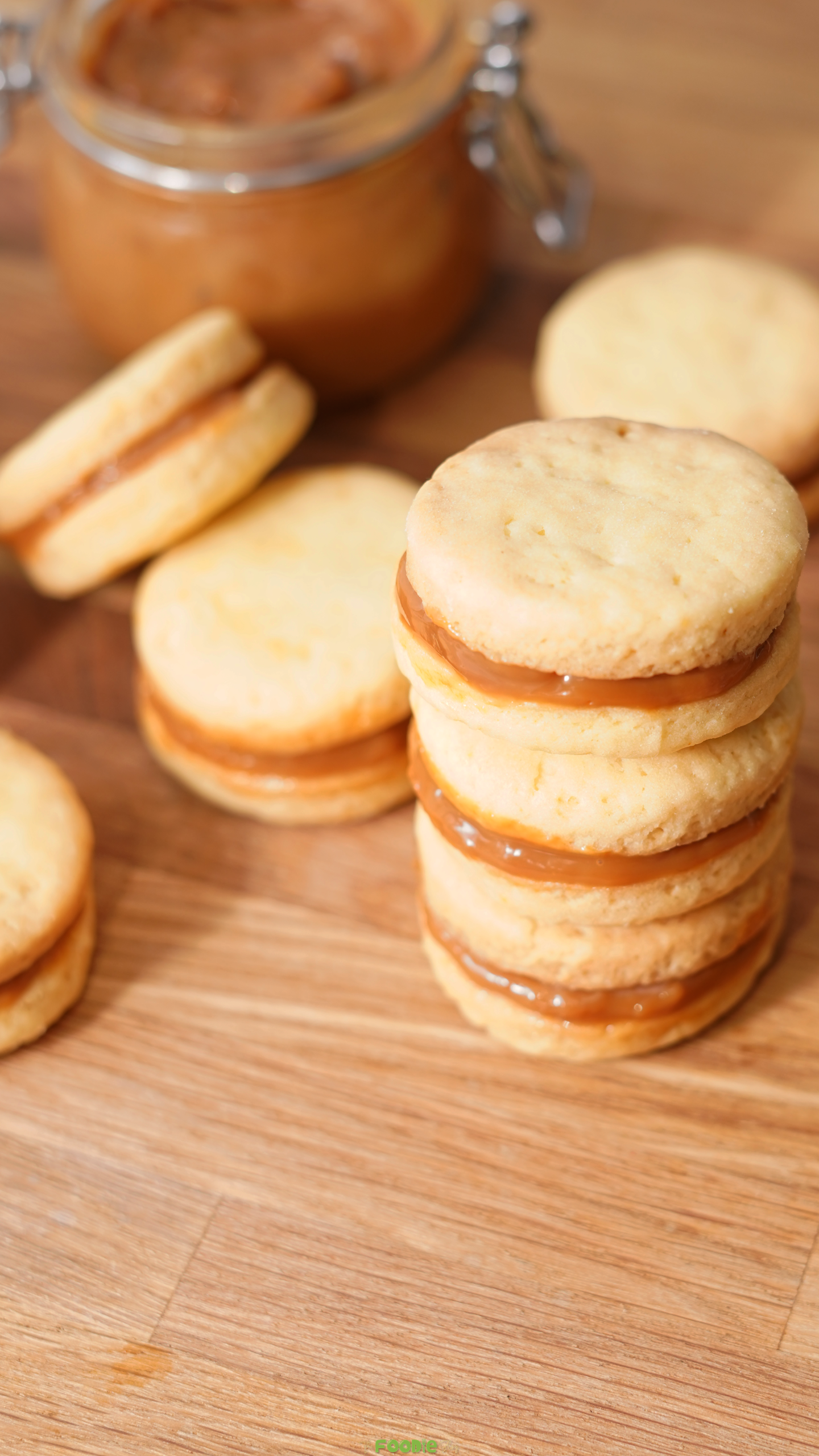 Close-up of stacked shortbread cookies filled with dulce de leche.