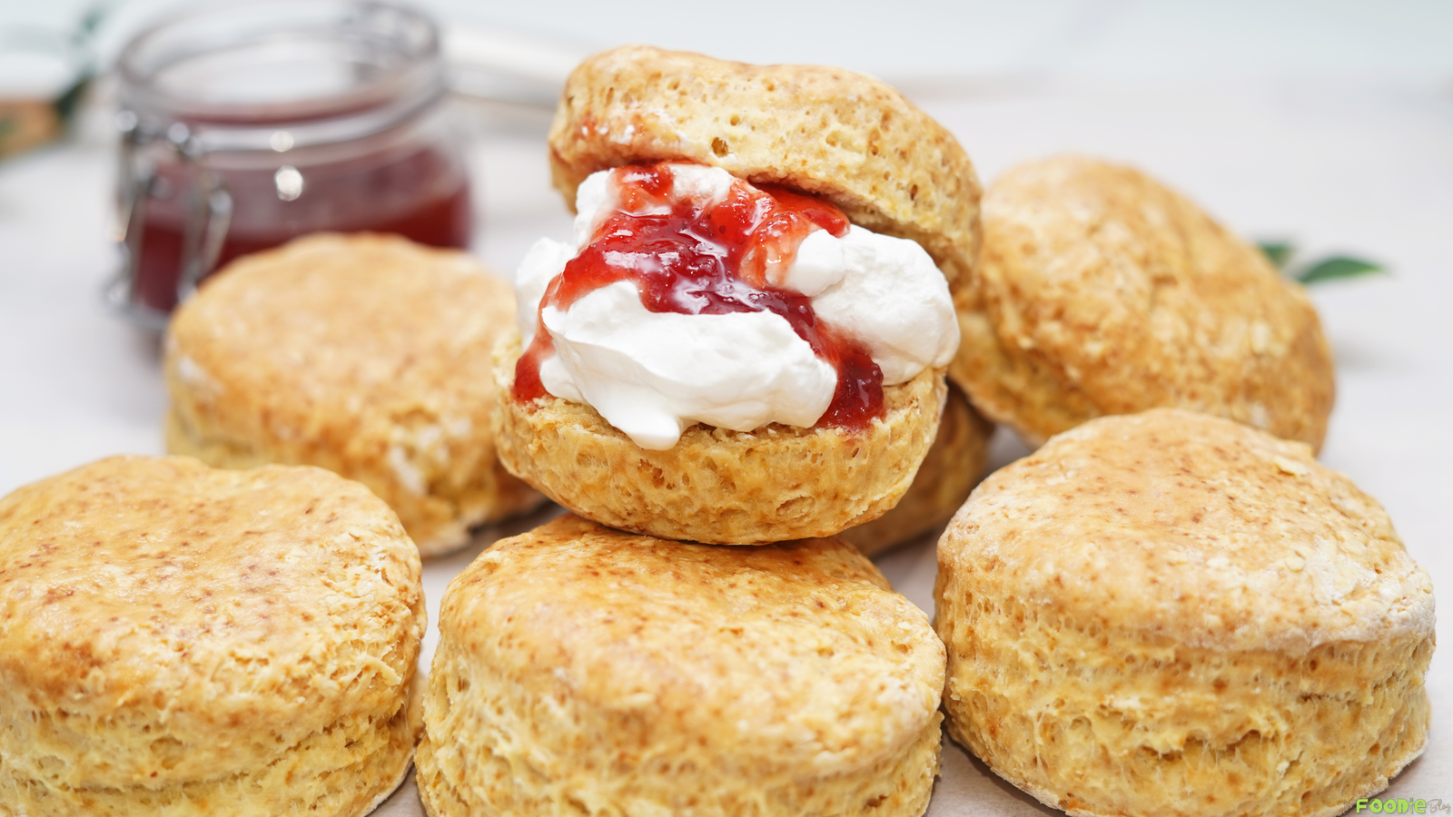 Golden homemade scones served with strawberry jam and whipped cream