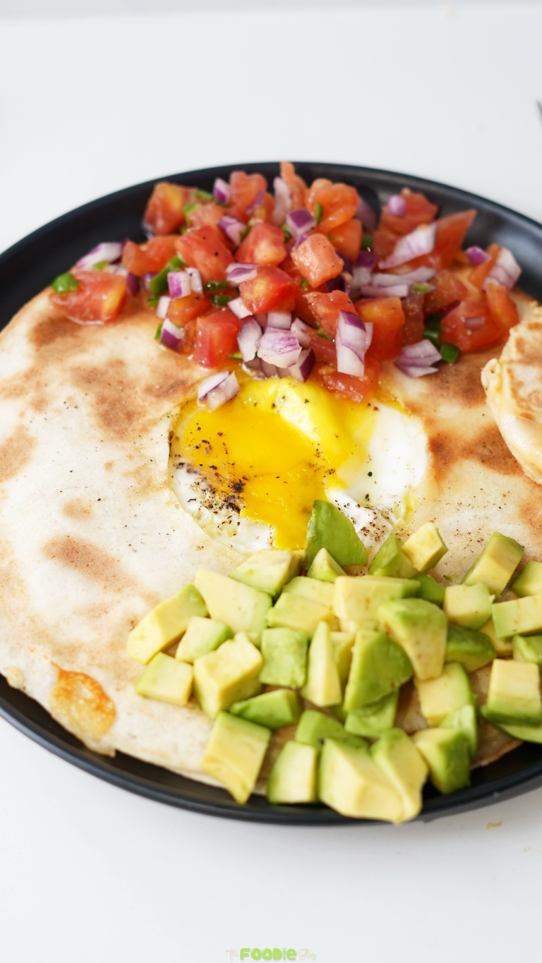 Close-up of Egg-In-A-Hole Quesadillas with tomato, onion, jalapeño, avocado, and a runny egg yolk.