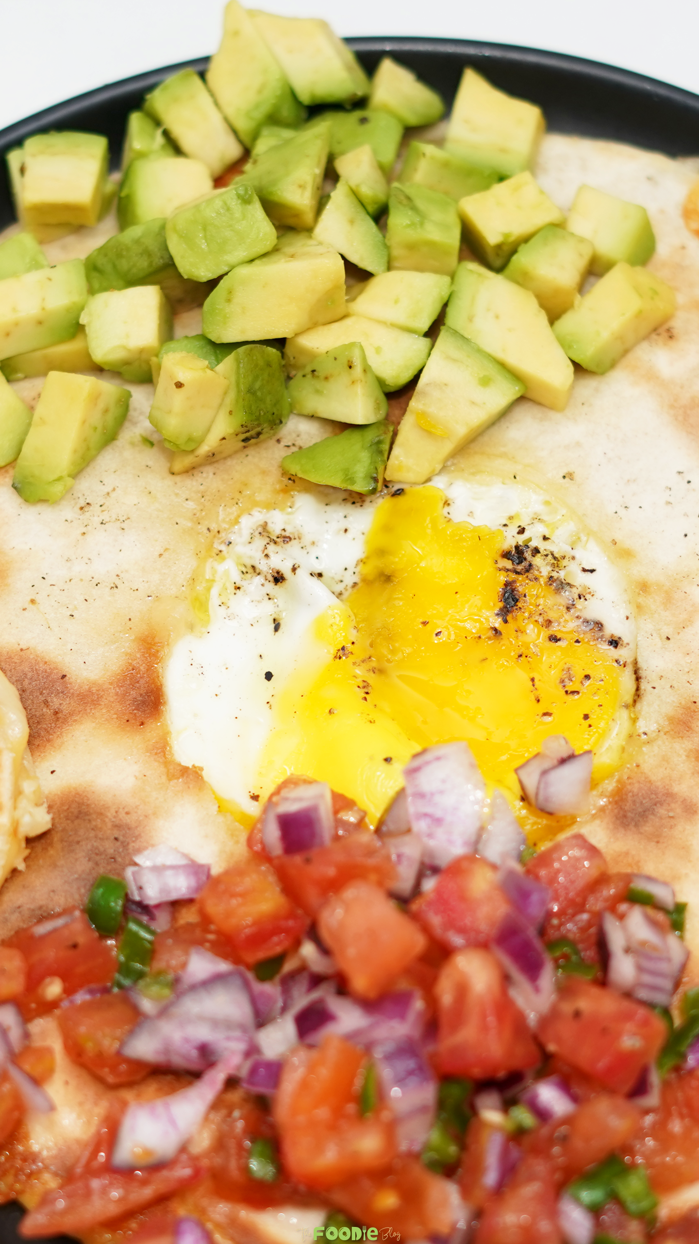 Close-up of the egg center in Egg-In-A-Hole Quesadillas with avocado and fresh tomato salsa.