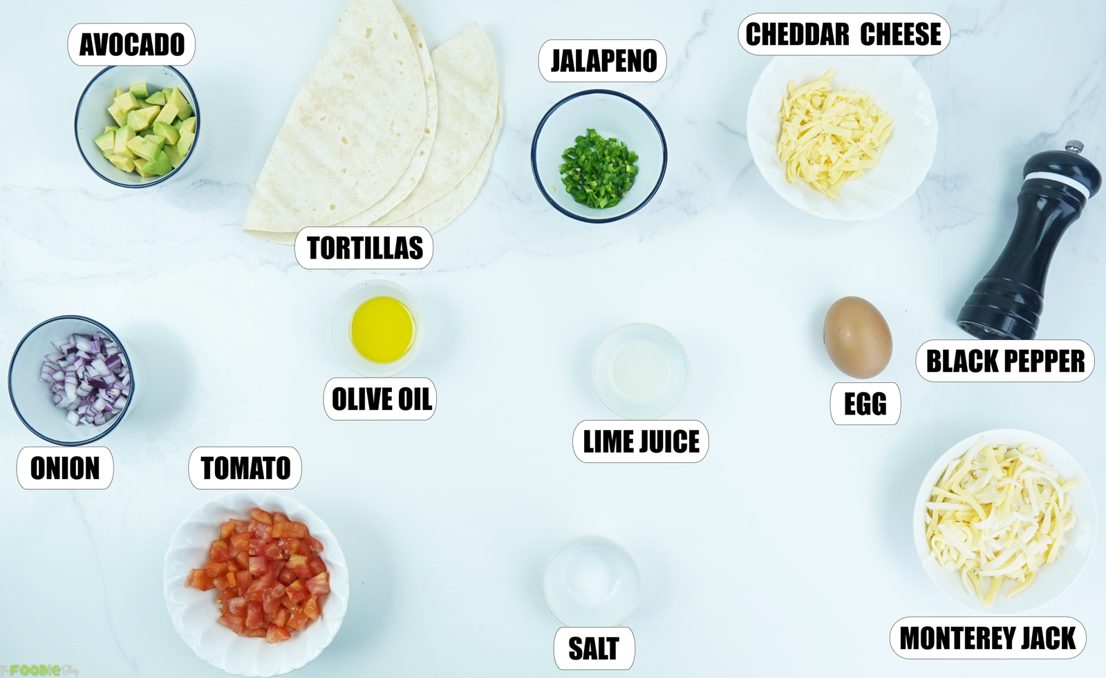 Ingredients for Egg-In-A-Hole Quesadillas with tortillas, egg, avocado, tomato, onion, jalapeño, cheese, lime juice, olive oil, salt, and black pepper.