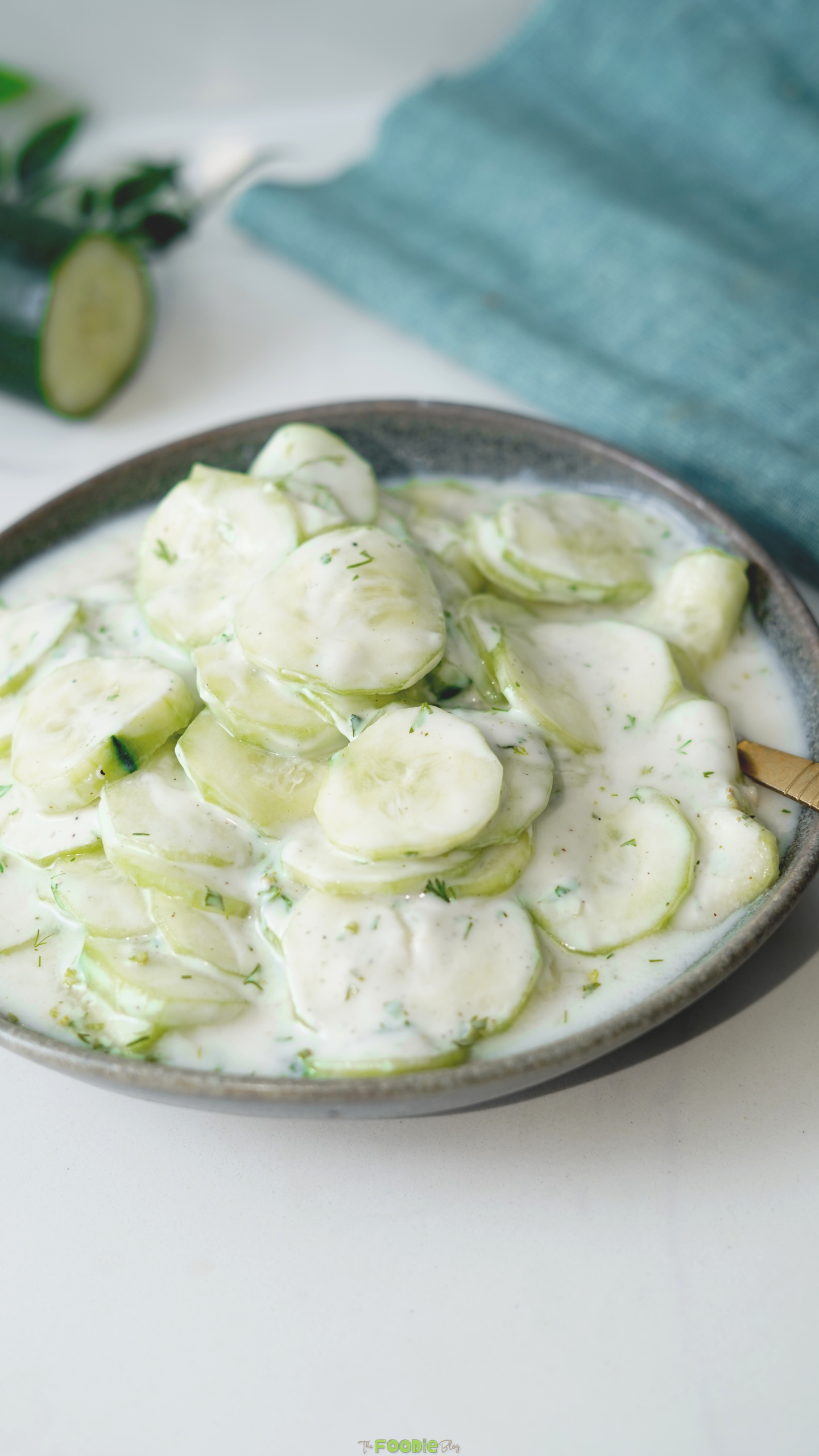 Close-up of creamy cucumber dill salad with black pepper and sour cream dressing.