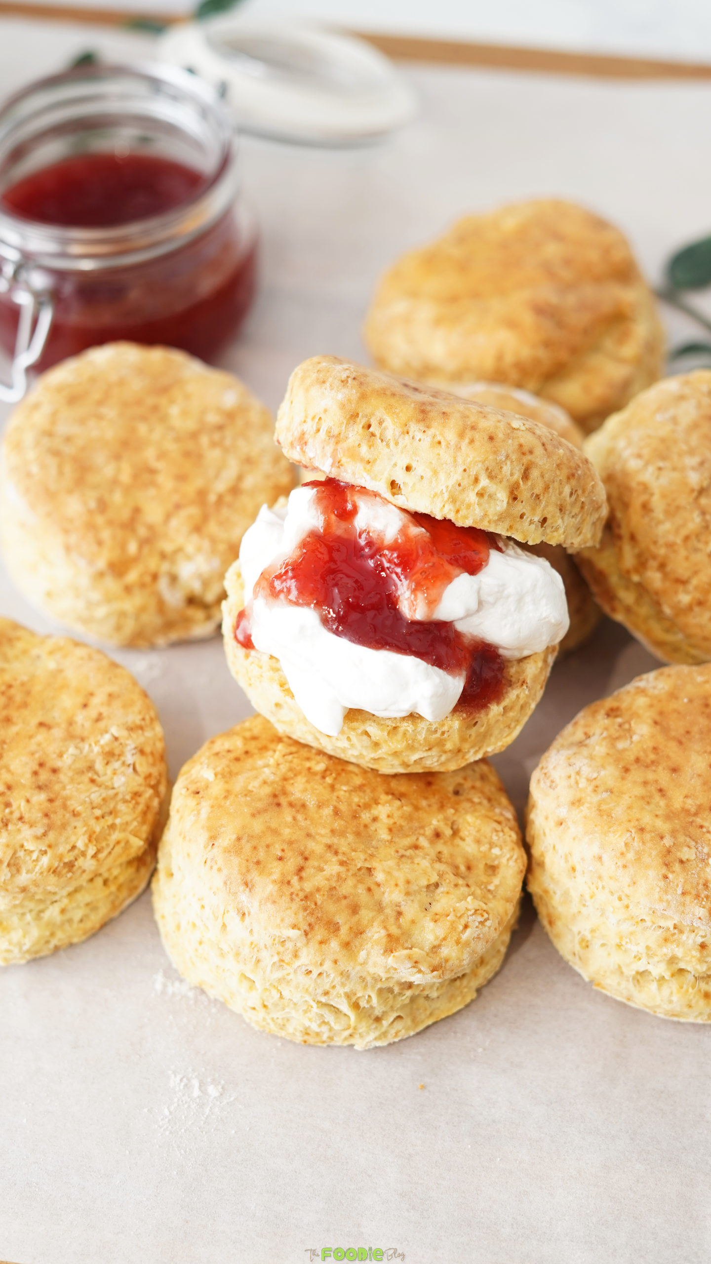 Homemade scone split open and filled with strawberry jam and whipped cream