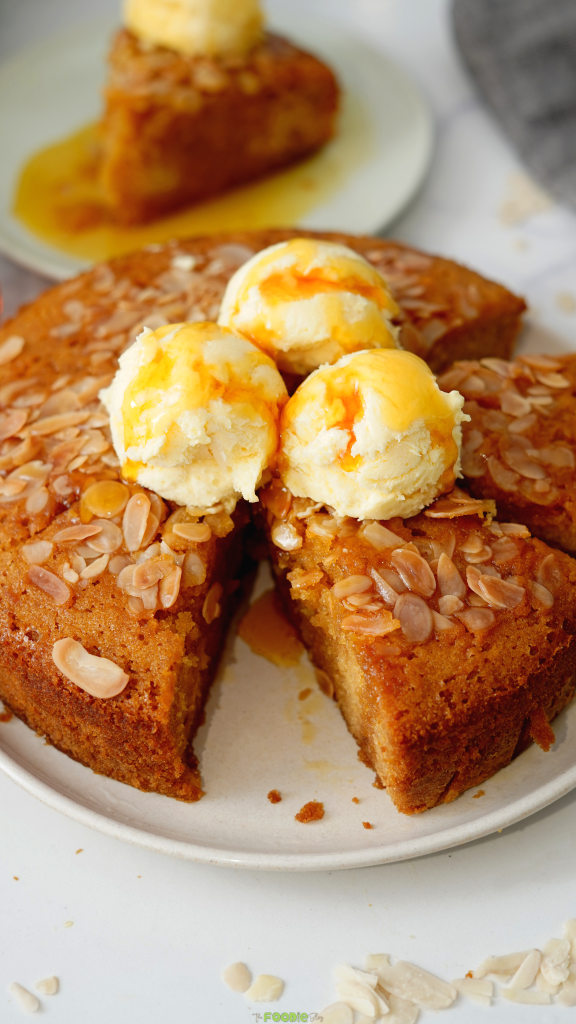 Honey cake topped with sliced almonds and vanilla ice cream