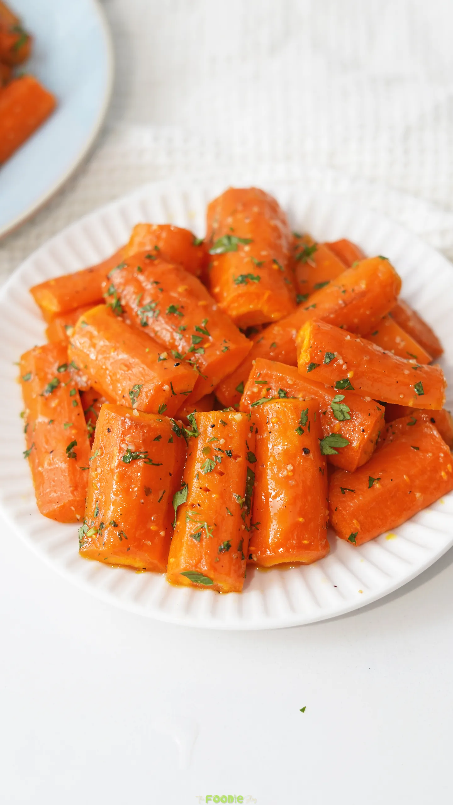 Honey Roasted Carrots served on a white plate with fresh herbs.