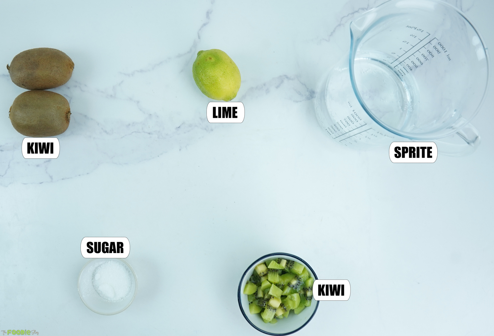 Kiwi, lime, sugar, Sprite, and chopped kiwi arranged for a homemade kiwi drin
