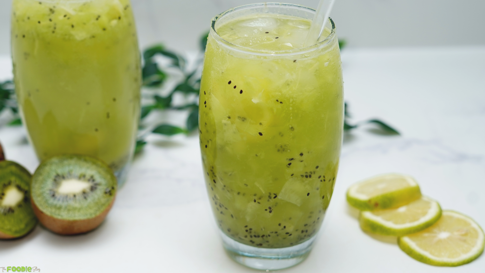 Two glasses of homemade kiwi lime soda with fresh kiwi pieces and chilled Sprite.