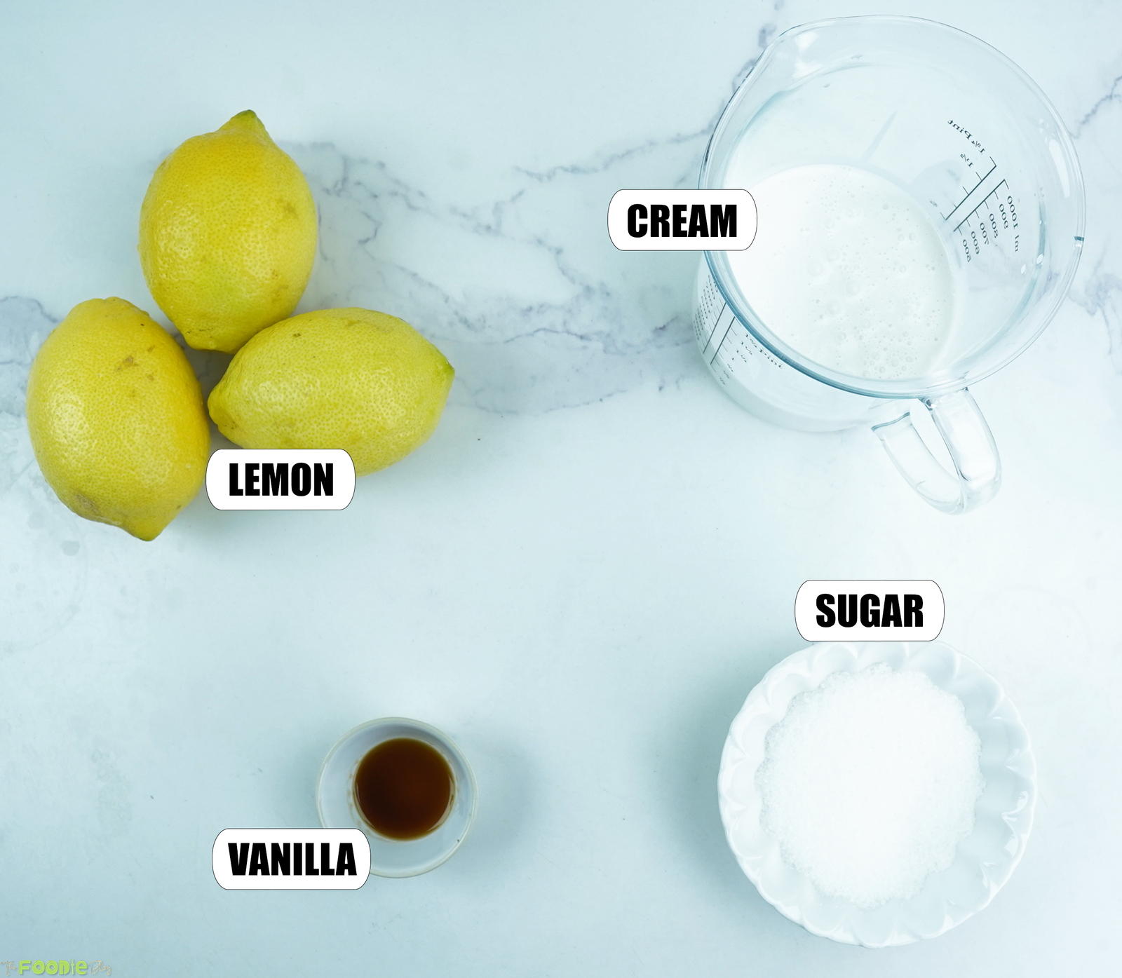 Fresh lemons, heavy cream, granulated sugar, and vanilla arranged for homemade lemon posset brûlée.