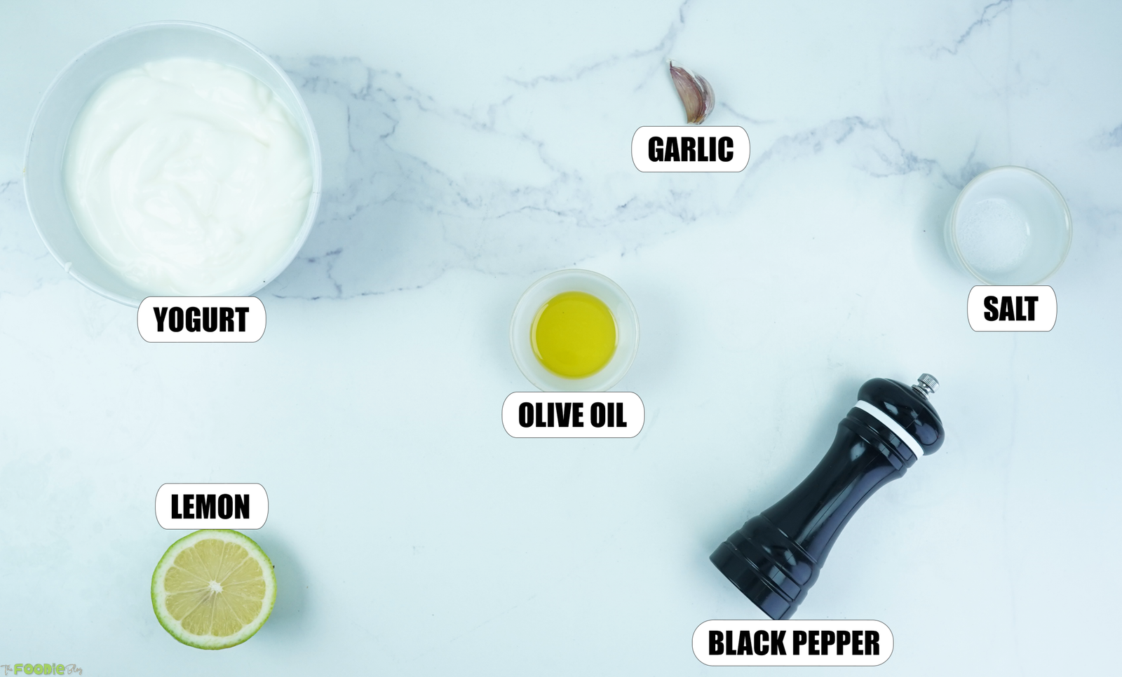 Plain yogurt, lemon, garlic, olive oil, salt, and black pepper arranged for lemon yogurt sauce.