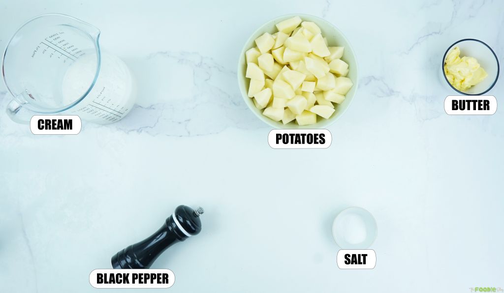 Ingredients for mashed potato recipe with potatoes, cream, butter, salt, and black pepper on a white surface.
