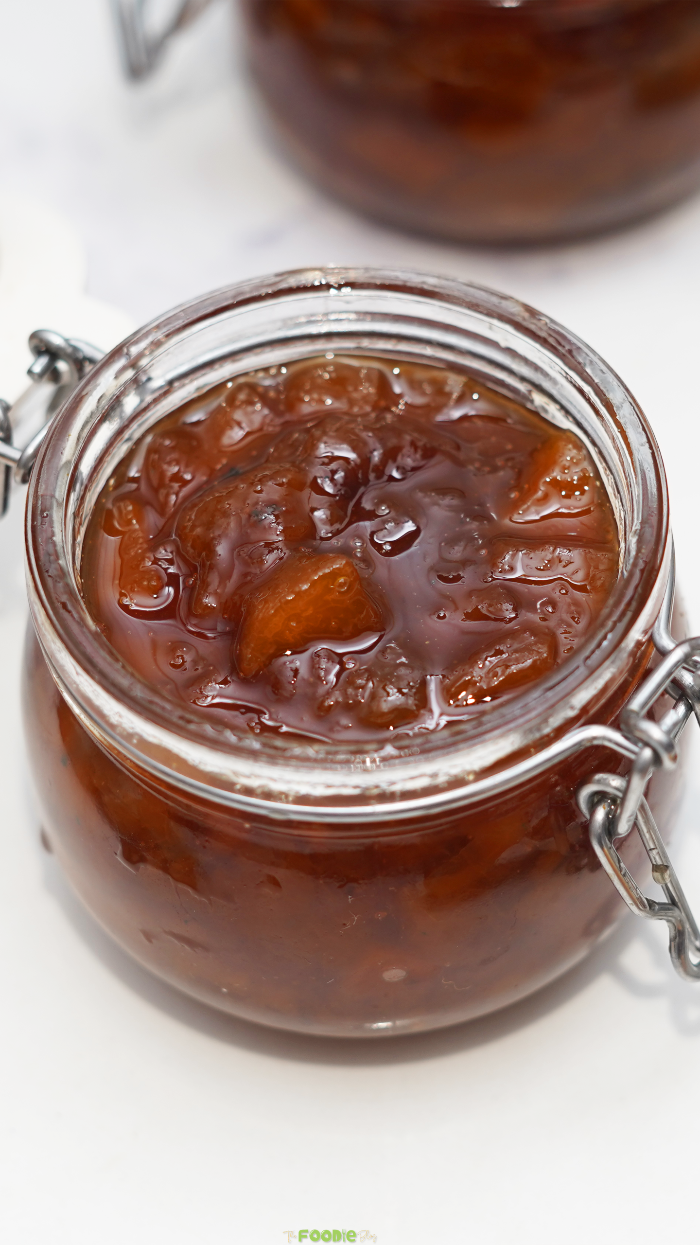 Homemade peach preserves with tender peach pieces in a glass jar.