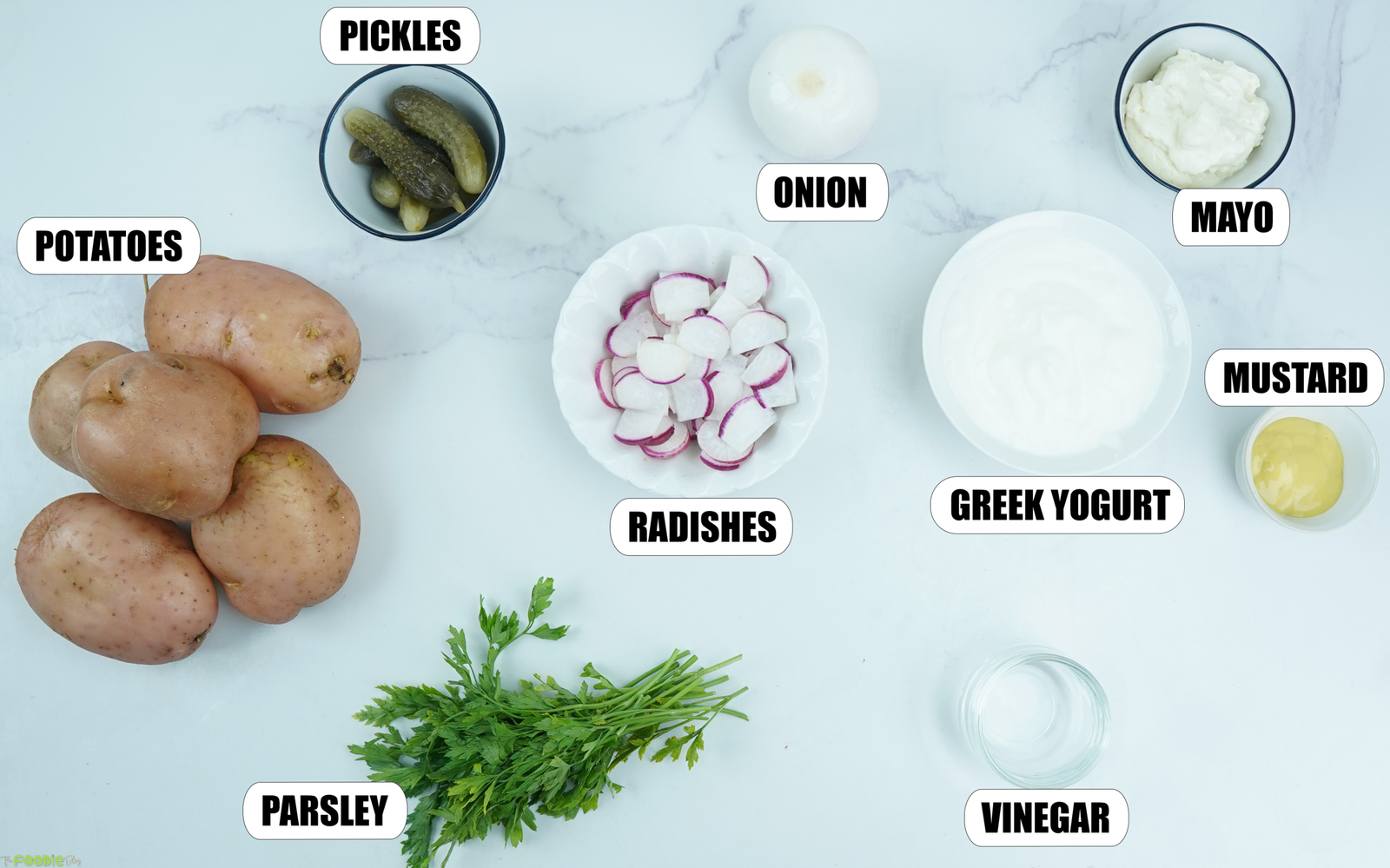 Ingredients for Potato Salad with potatoes, pickles, onion, radishes, parsley, Greek yogurt, mayo, mustard, and vinegar.