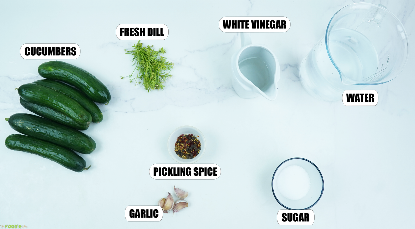 Ingredients for refrigerator dill pickles including cucumbers, fresh dill, white vinegar, water, garlic, sugar, and pickling spice.