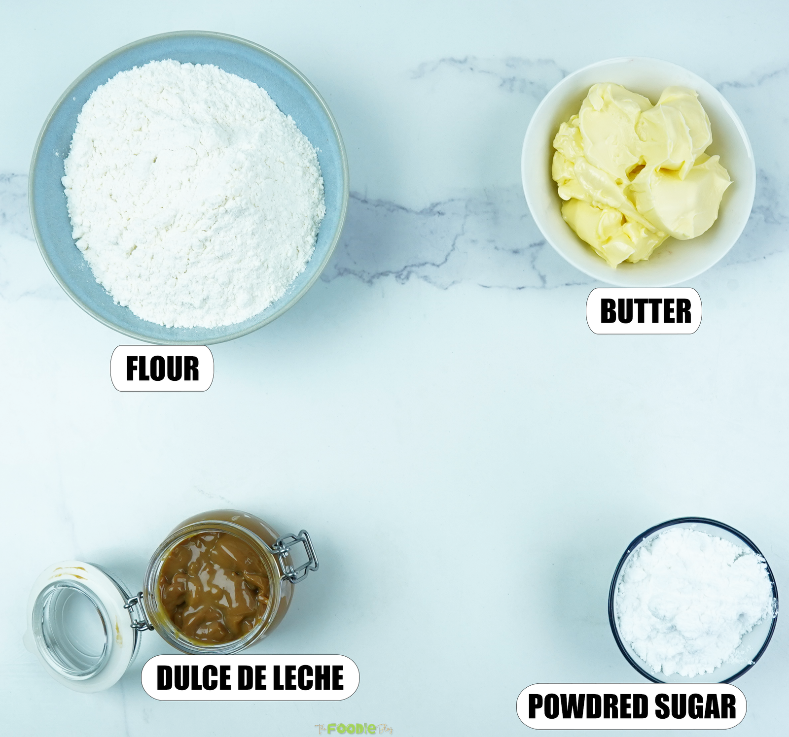 Flour, butter, powdered sugar, and dulce de leche arranged for shortbread cookie sandwiches.