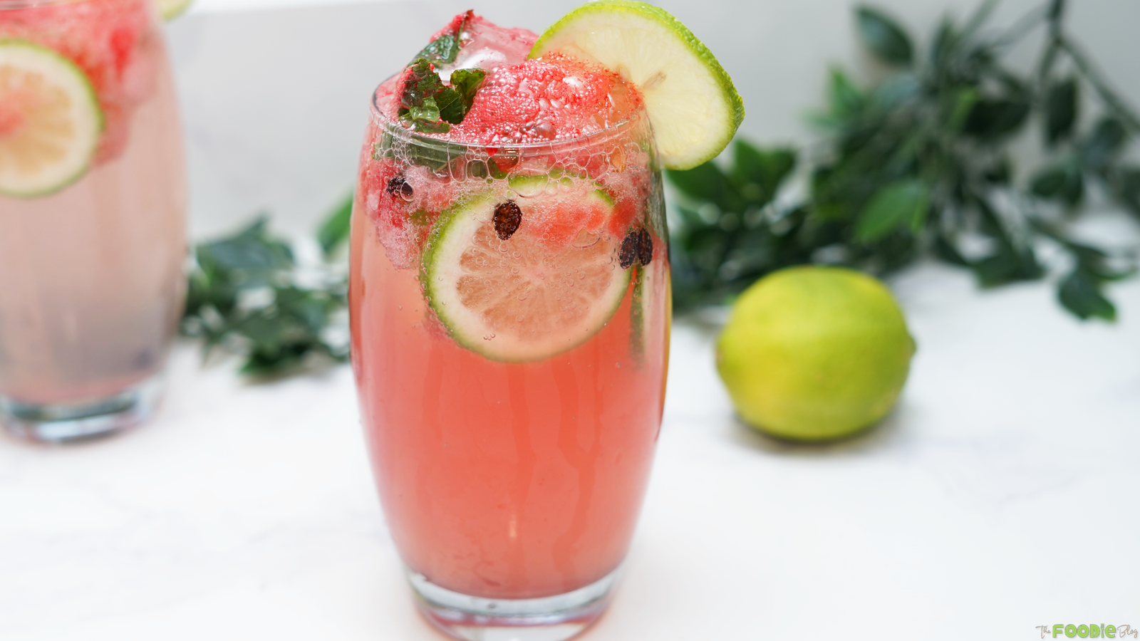 A glass of watermelon mojito mocktail with mint, lime, watermelon, and sparkling bubbles.