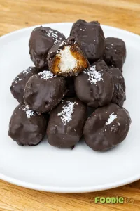 Chocolate-covered Bounty dates stuffed with coconut filling and topped with shredded coconut