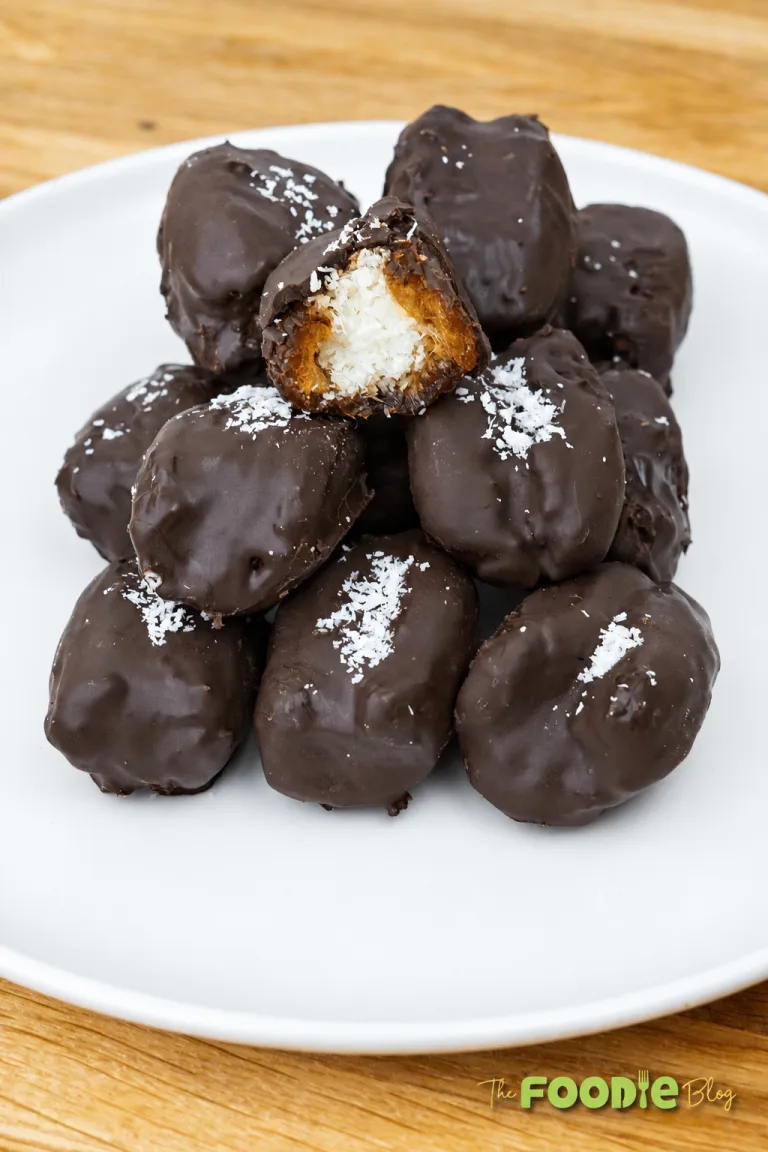 Chocolate-covered Bounty dates stuffed with coconut filling and topped with shredded coconut