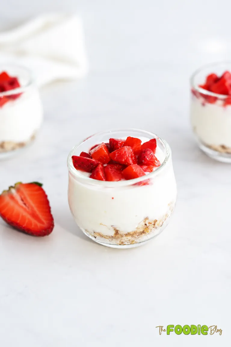 Strawberry protein cheesecake cups with creamy filling, oat pecan crust, and fresh strawberries