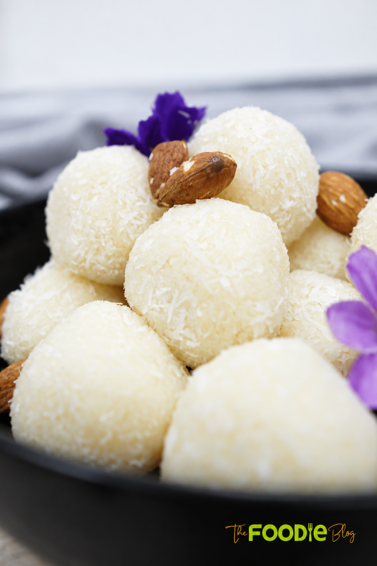 Homemade Raffaello coconut balls coated in desiccated coconut with whole almonds