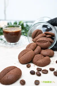 Coffee bean shaped chocolate coffee cookies served with a cup of coffee