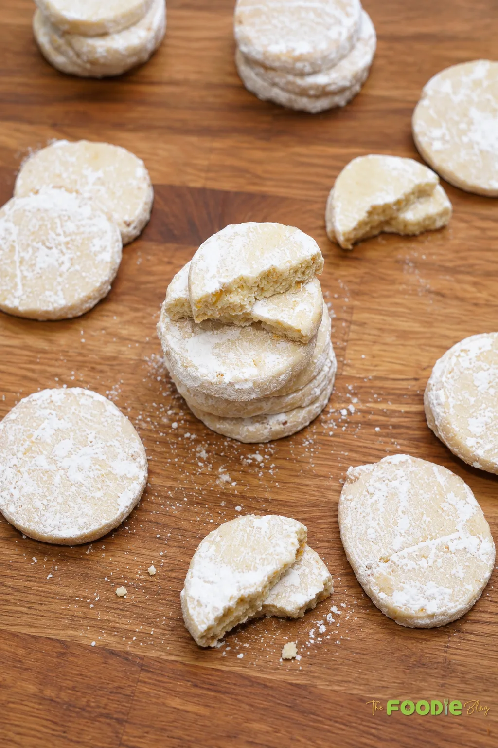 Homemade lime meltaway cookies dusted with powdered sugar on a wooden board