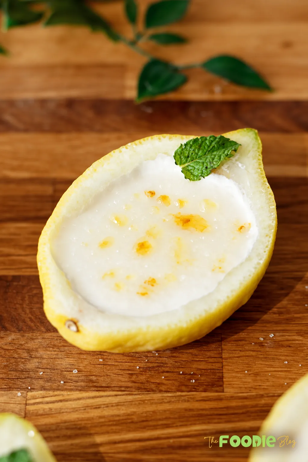 Creamy lemon posset served inside fresh lemon shells and garnished with mint