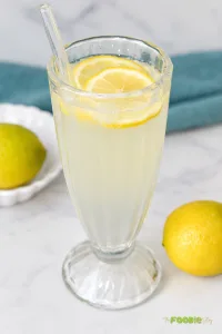 Homemade lemonade served in a tall glass with fresh lemon slices