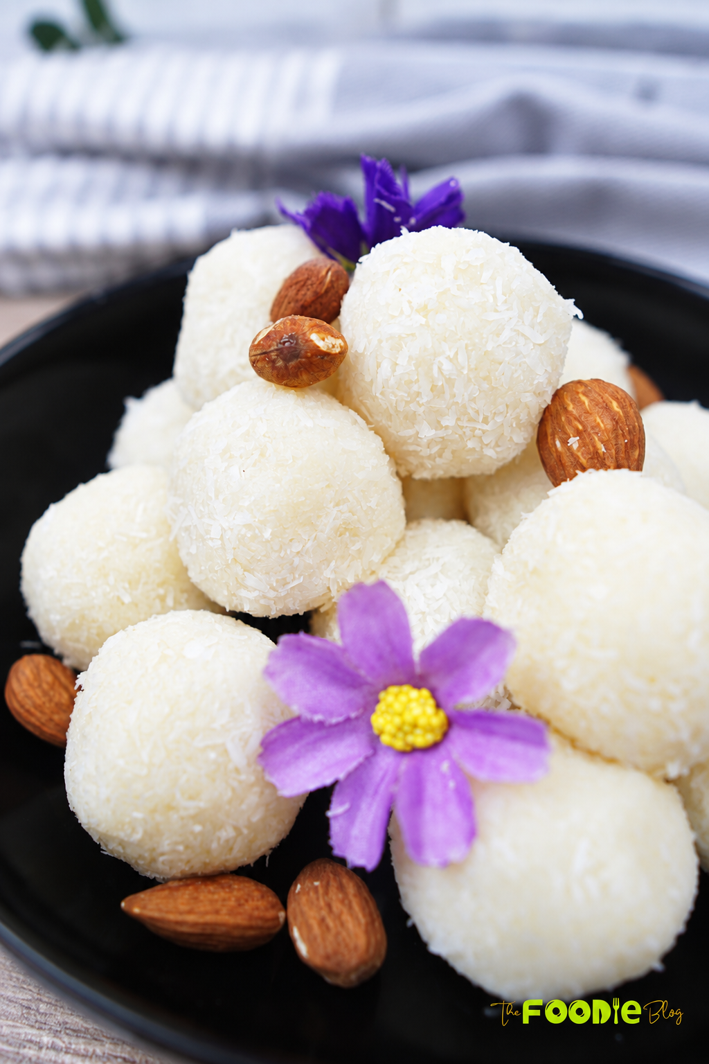 Coconut balls coated in shredded coconut and served with whole almonds