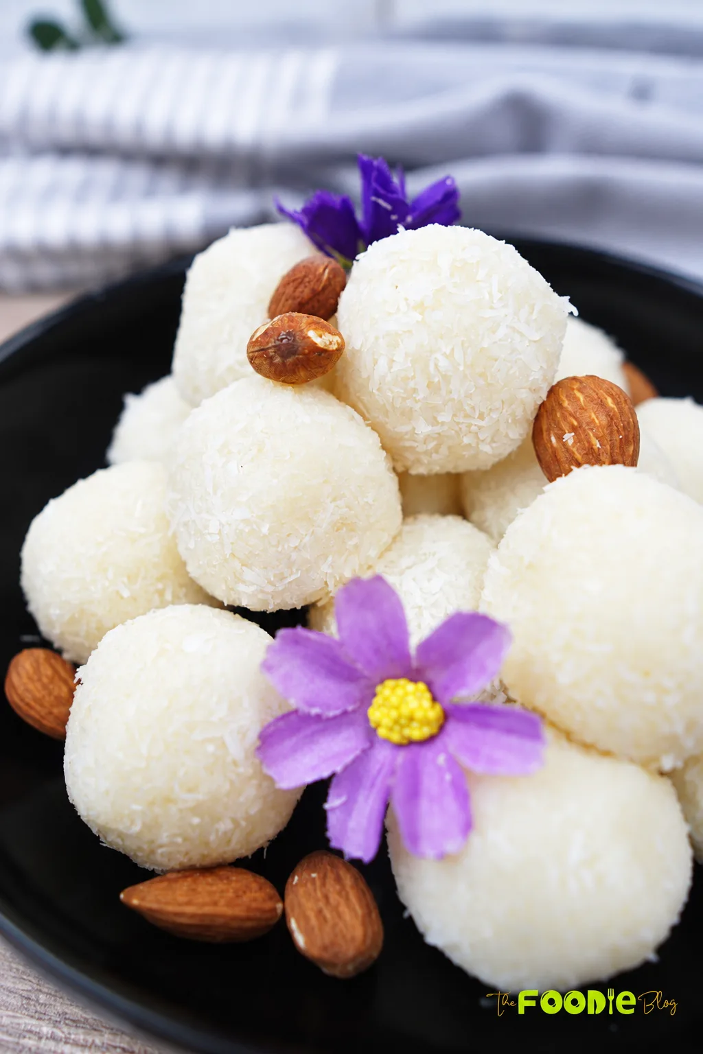 Coconut balls coated in shredded coconut and served with whole almonds