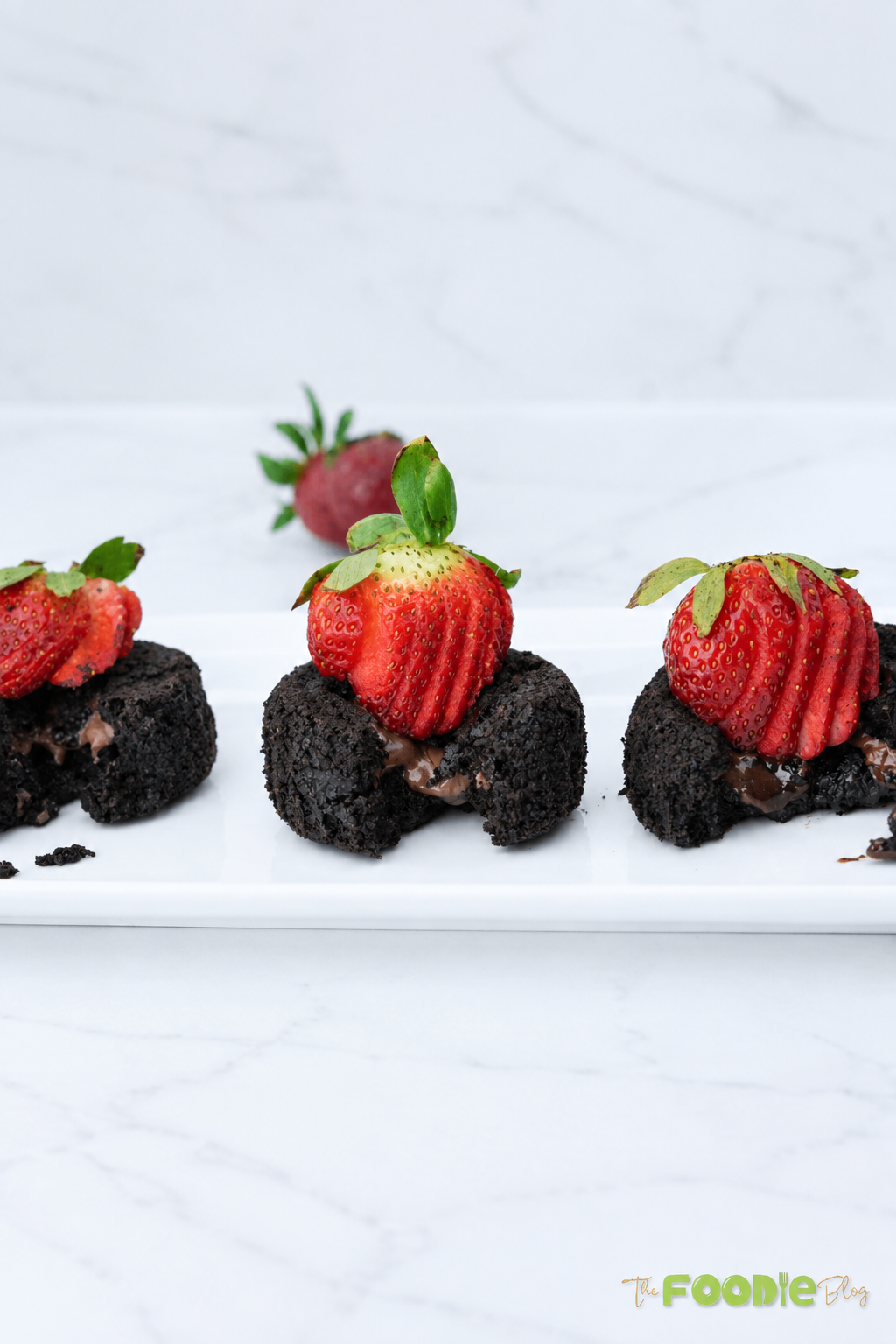 Mini chocolate oatmeal lava cakes filled with melted chocolate and topped with strawberries