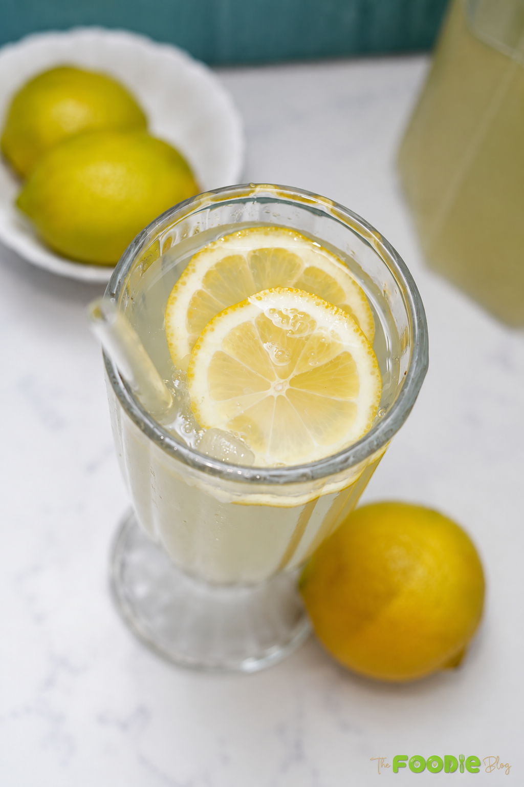 Fresh homemade lemonade with lemon slices and whole lemons
