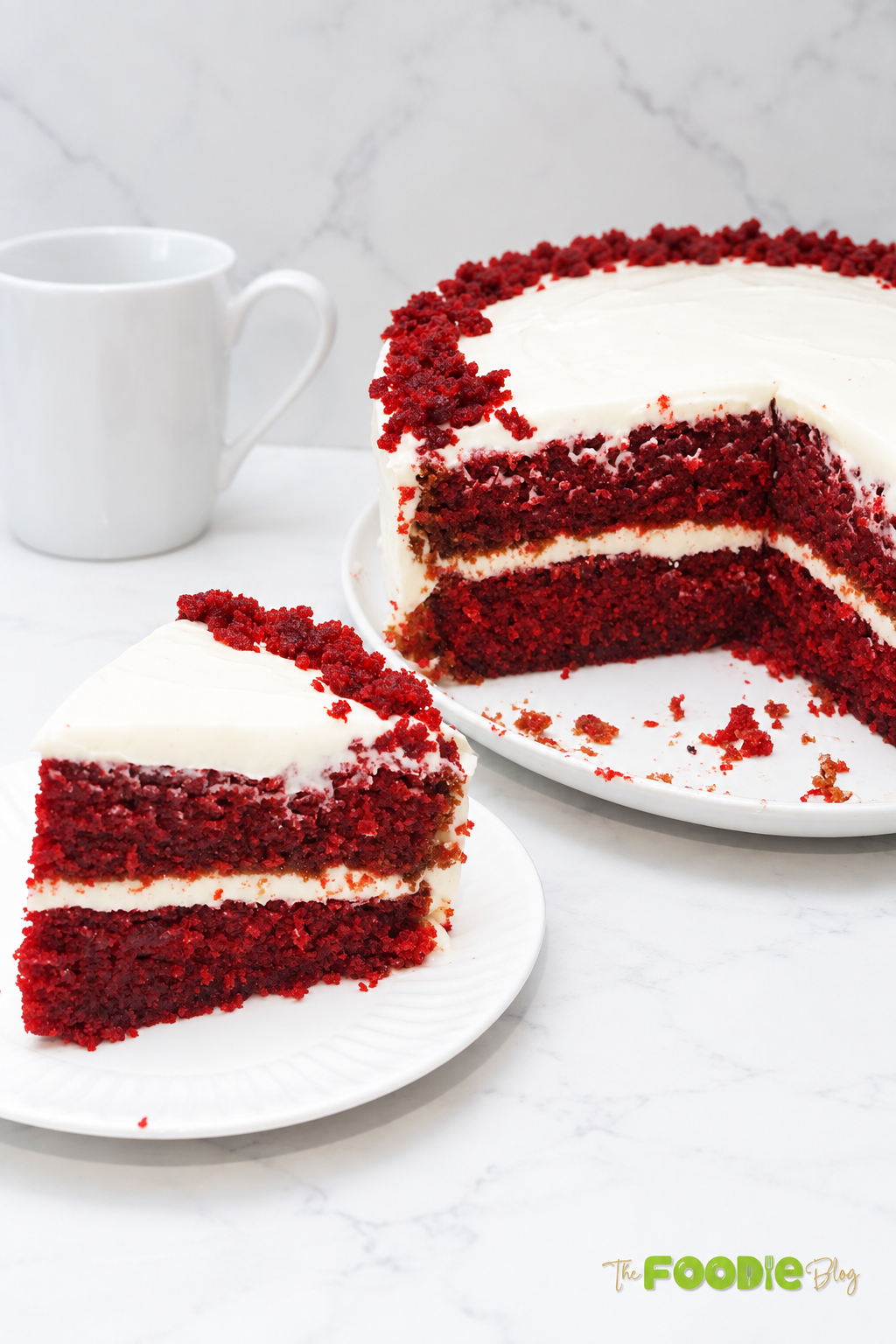 Slice of red velvet cake with cream cheese frosting lifted above the whole cake