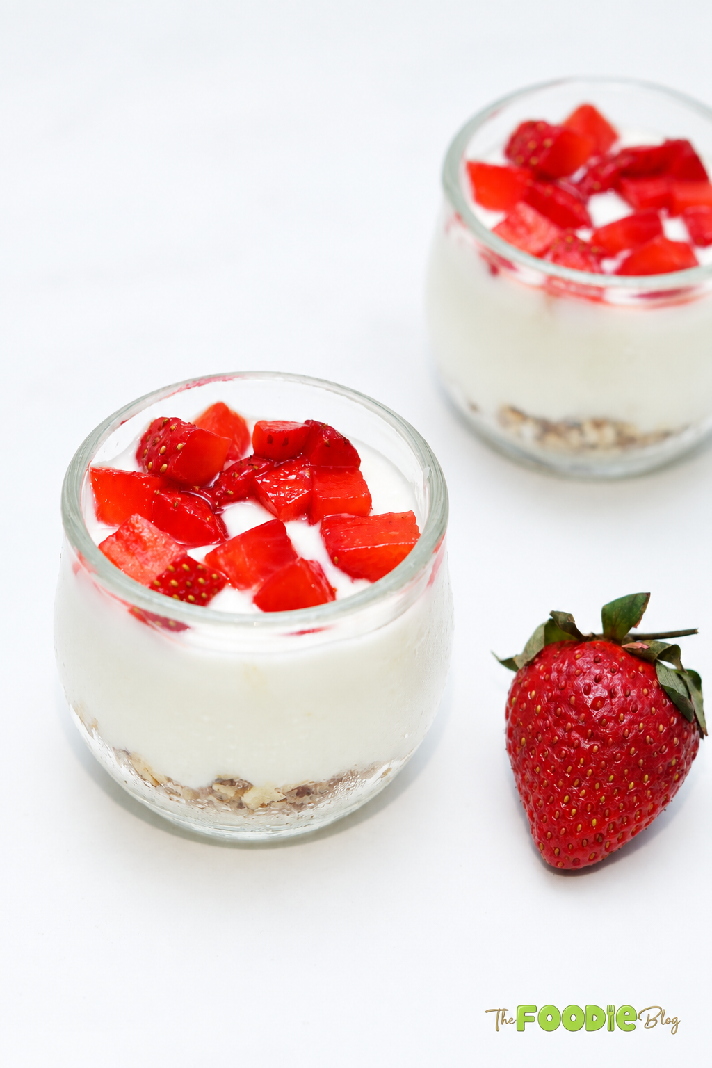 No-bake strawberry cheesecake cups topped with chopped fresh strawberries