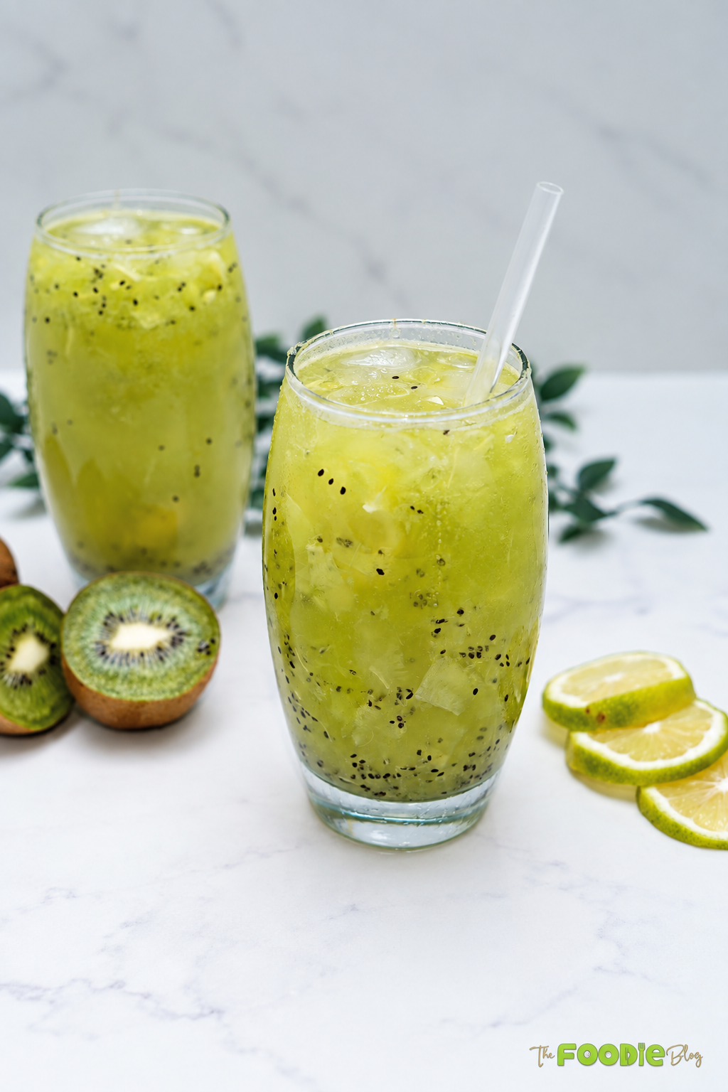 Two glasses of kiwi lime drink with fresh kiwi pieces, ice, and Sprite