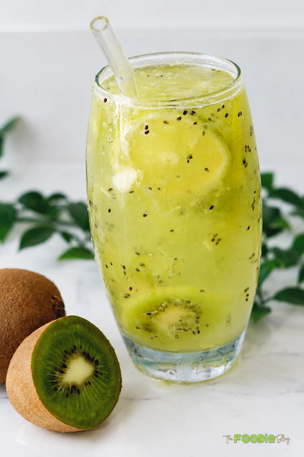 Close-up of fresh kiwi lime drink with kiwi pieces, ice, and lime
