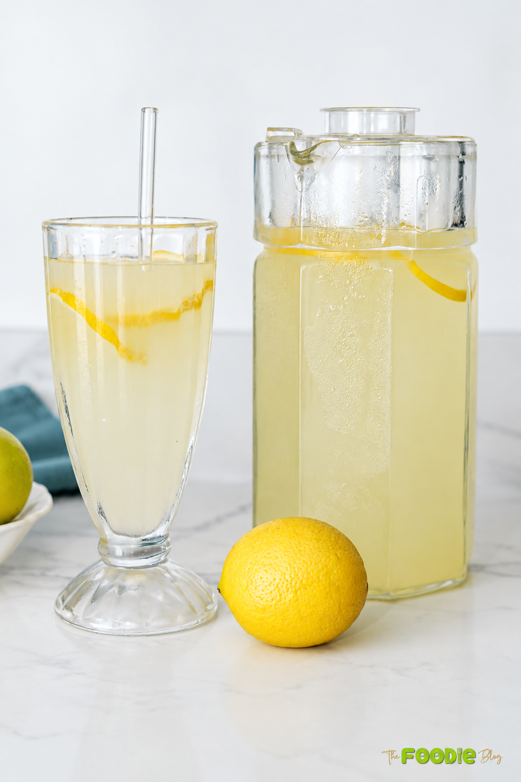 Pitcher and glass of homemade lemonade with fresh lemon slices