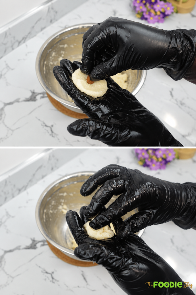 Whole almond being placed inside coconut mixture before shaping into a ball