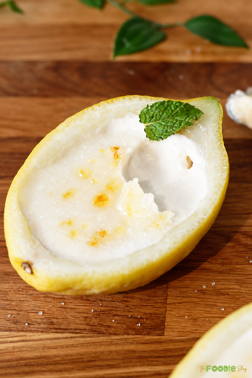 Close-up of creamy lemon posset in a lemon shell with a spoonful removed