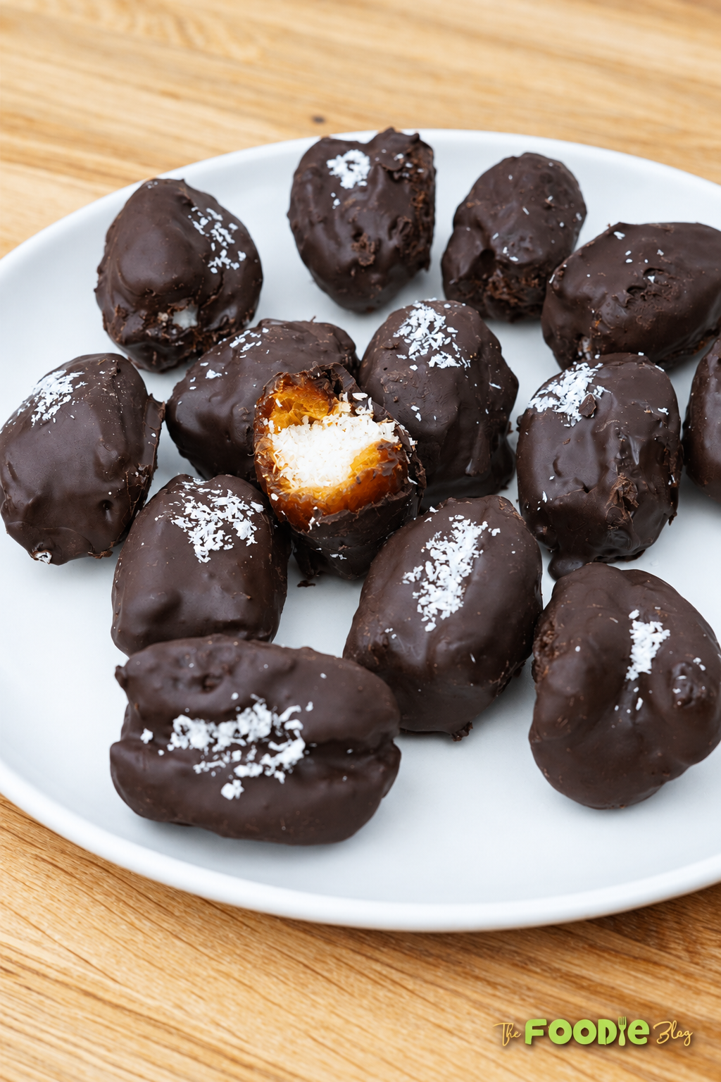 Close-up of chocolate-covered Medjool dates showing the white coconut filling inside