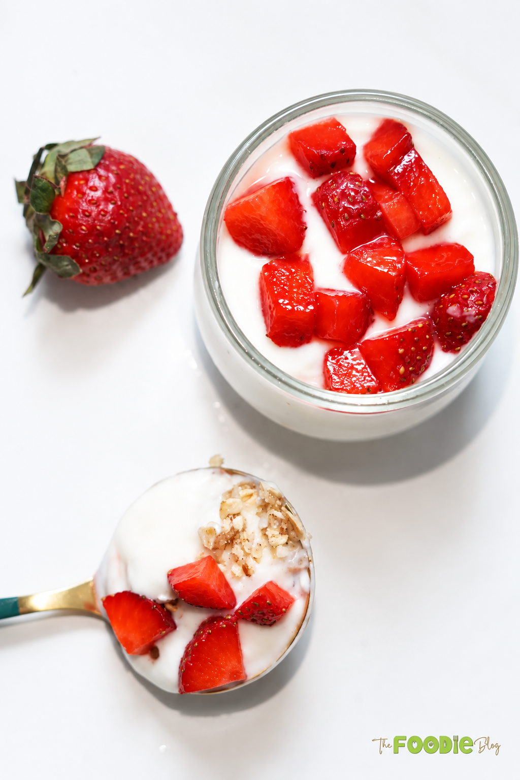 Spoonful of strawberry protein cheesecake with creamy filling, oat pecan crust, and strawberries