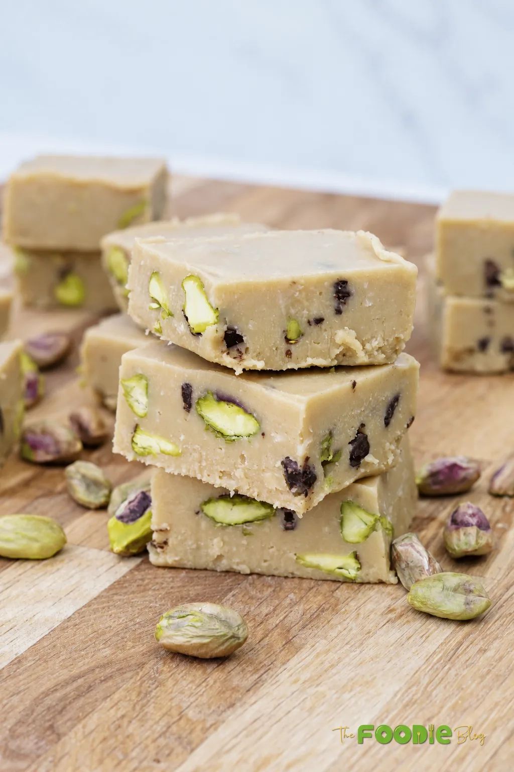 Close-up of creamy tahini fudge squares filled with pistachios and chocolate chips