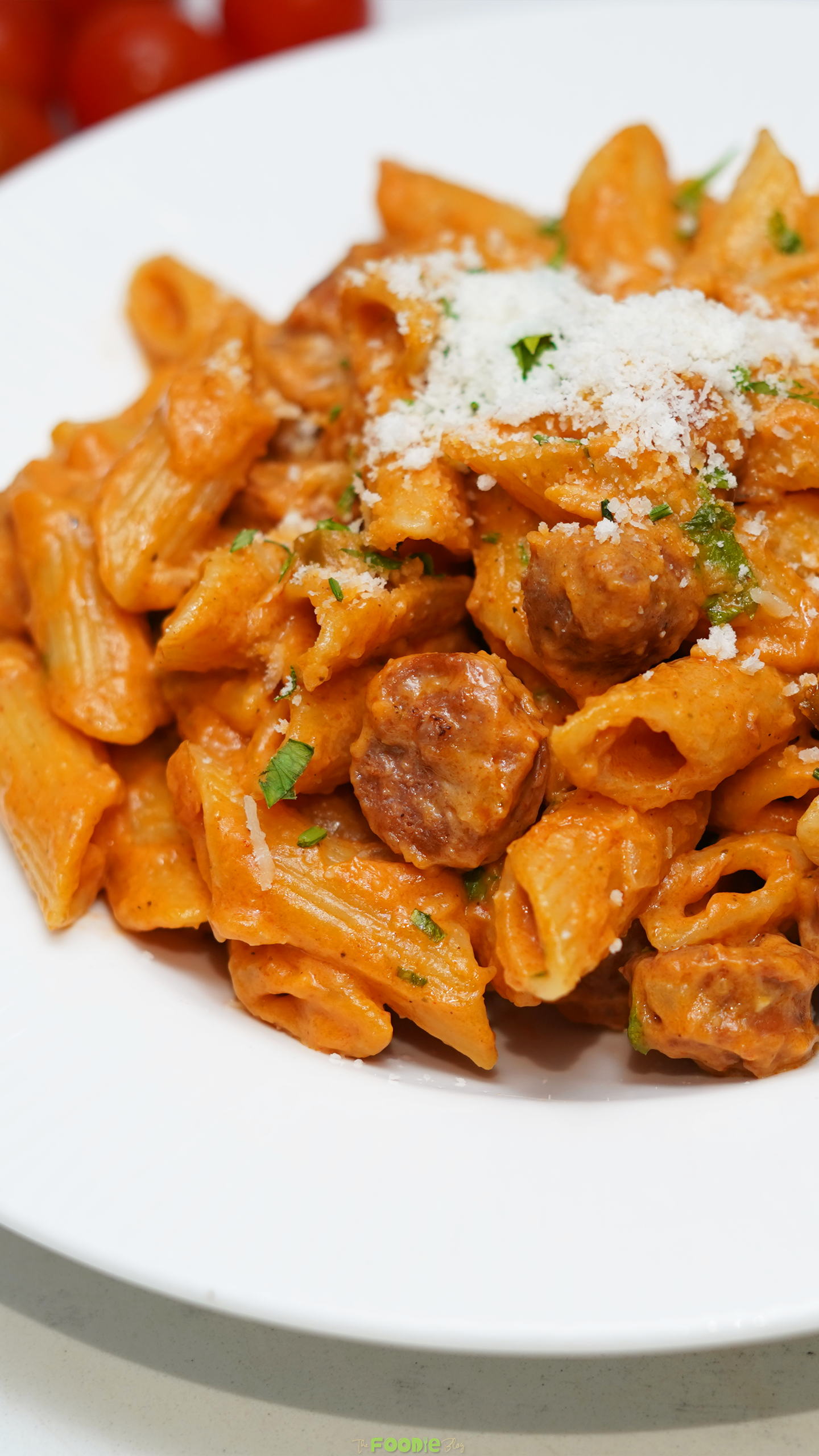 Close-up of creamy Cajun penne pasta with smoked sausage, Parmesan cheese, and fresh parsley.