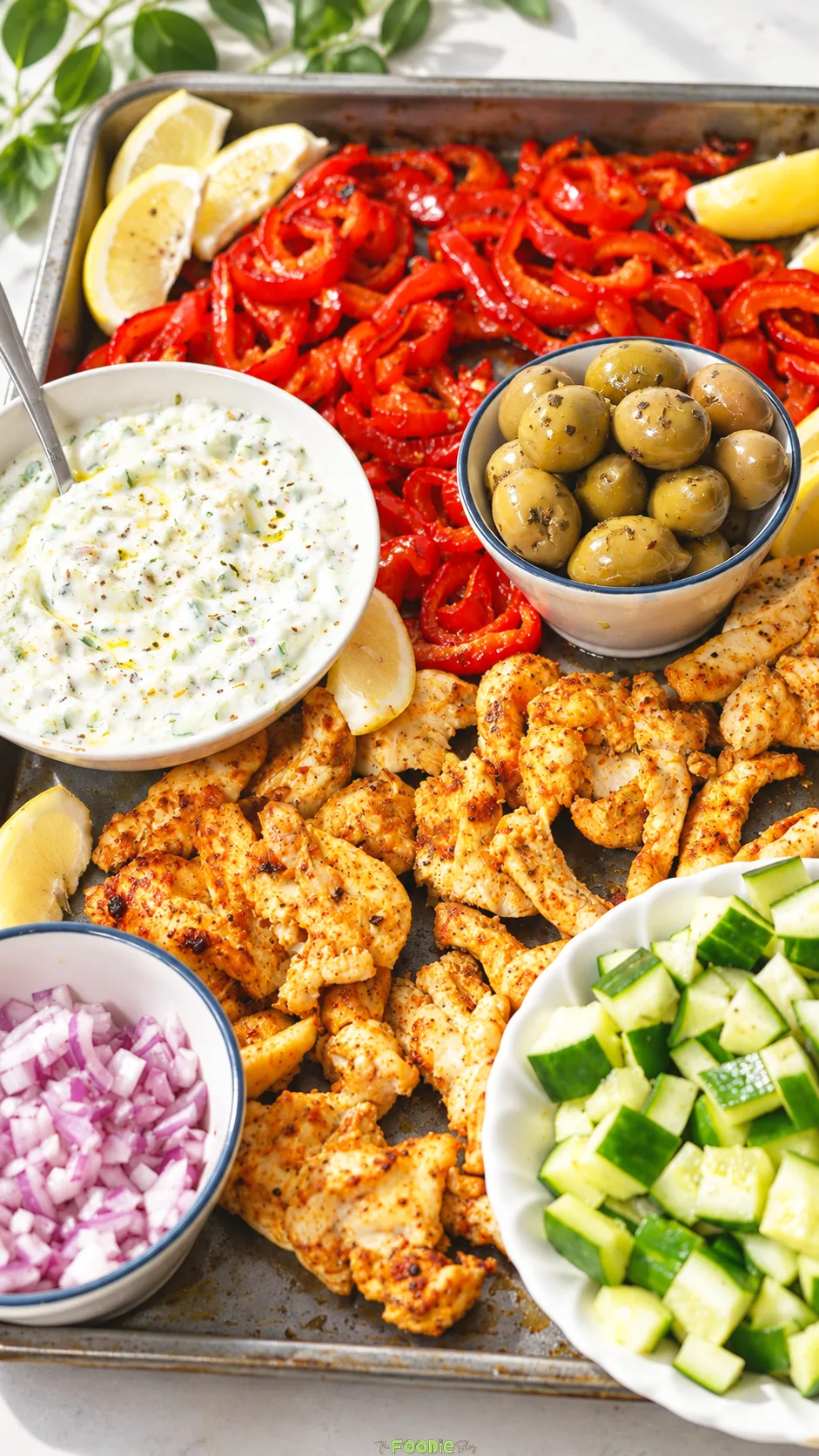 Chicken pita platter with roasted peppers, cucumber, red onion, olives, lemon, and tzatziki sauce.