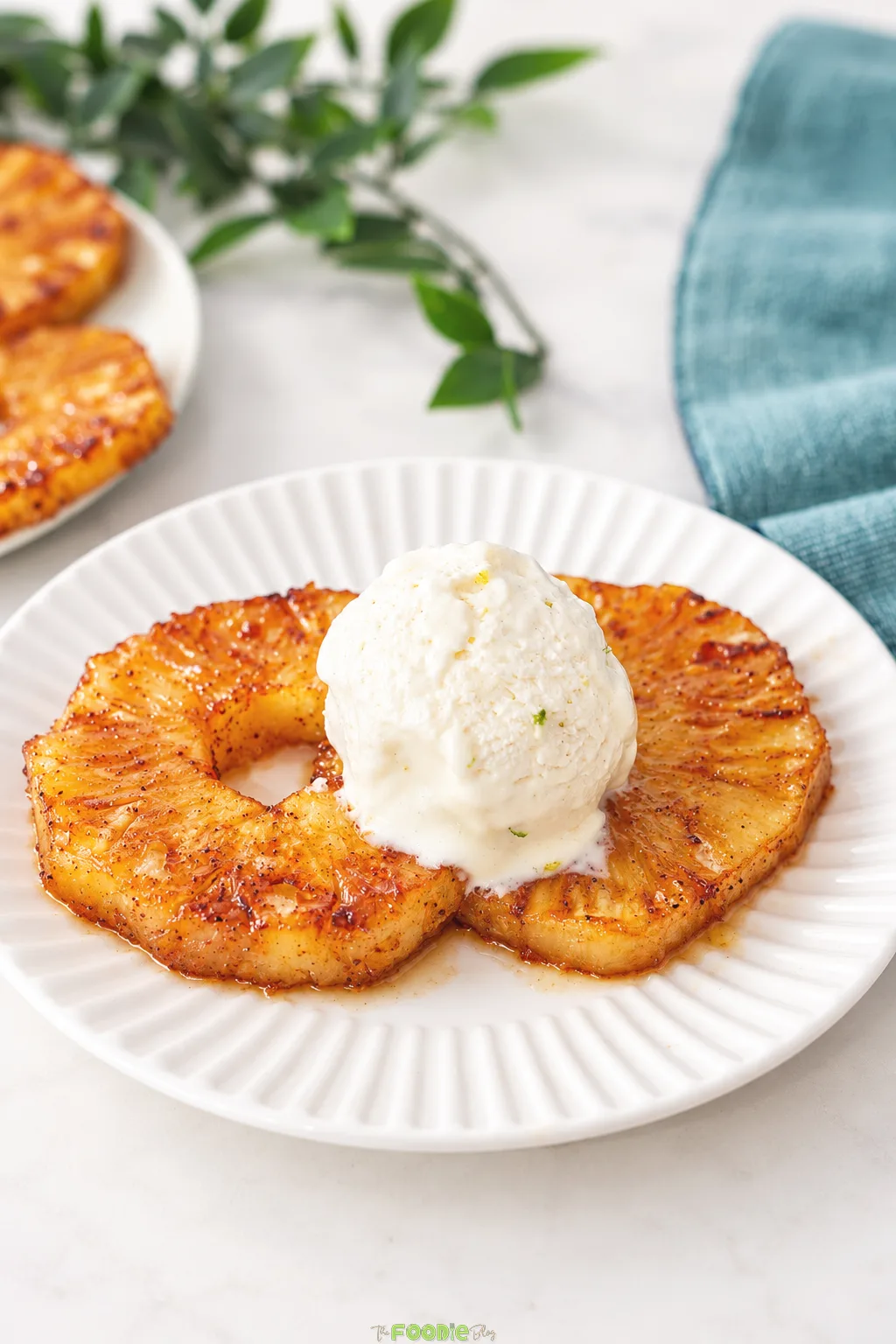 Grilled pineapple rings with brown sugar and cinnamon served warm with vanilla ice cream.