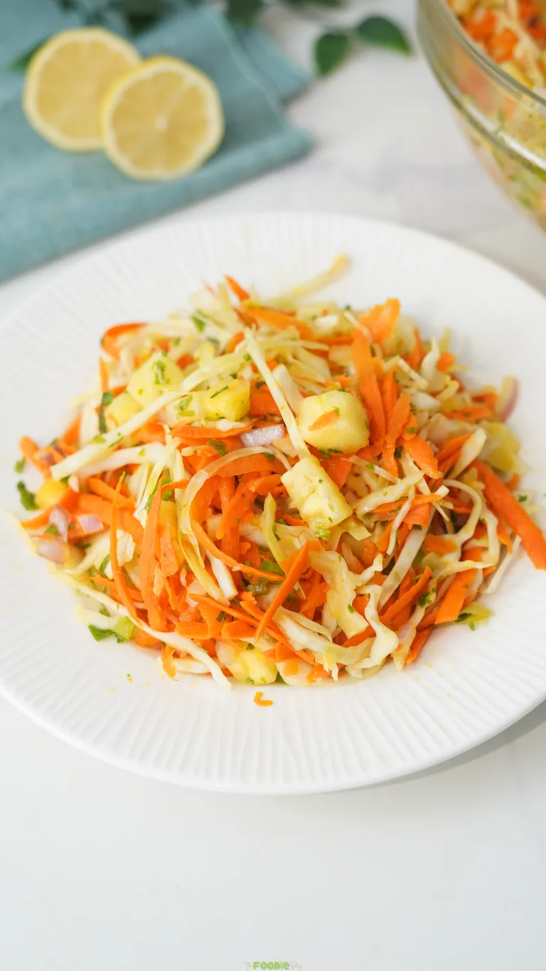 No-mayo pineapple coleslaw with cabbage, shredded carrot, pineapple chunks, red onion, and cilantro.