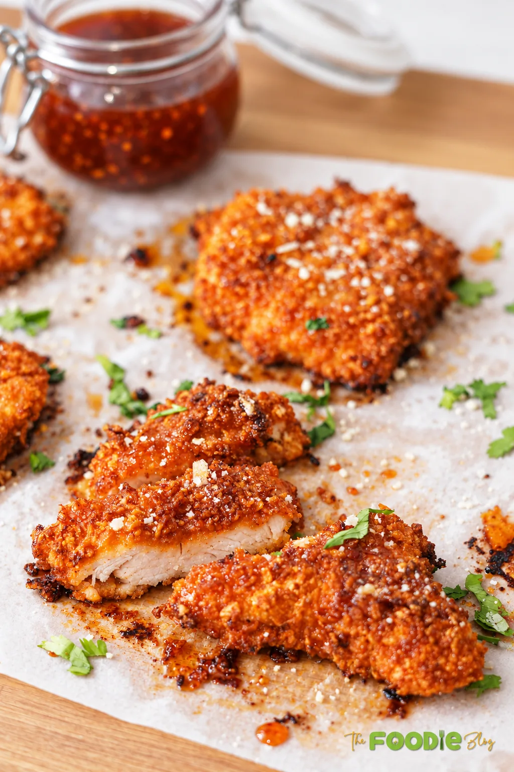 Baked crunchy hot honey chicken with a crispy cornflake coating, hot honey glaze, Parmesan, and fresh cilantro.