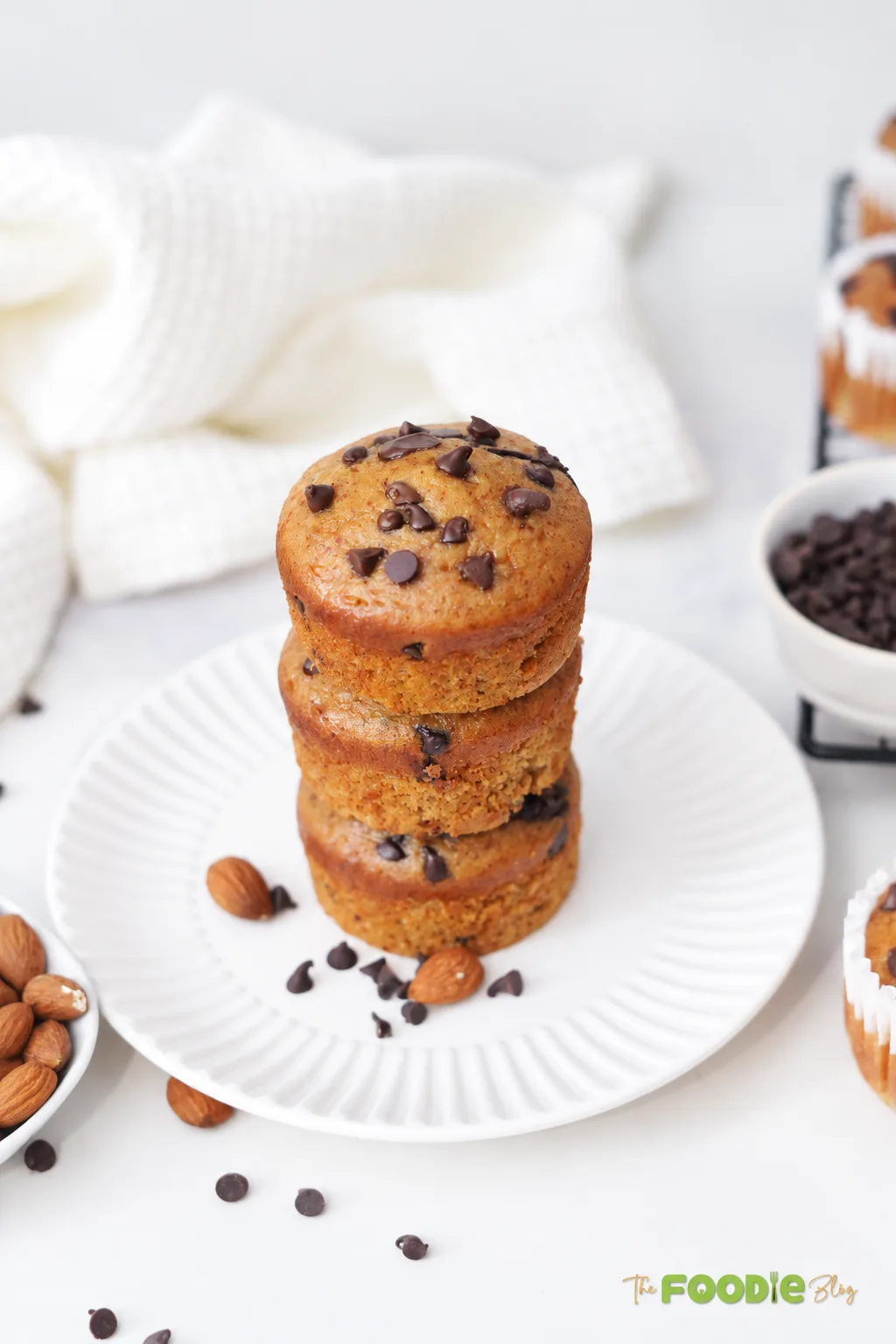 Stack of banana protein muffins with chocolate chips on a white plate.