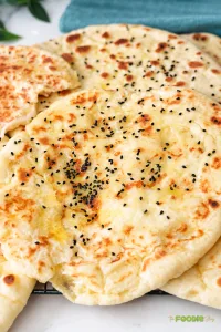Cheese naan bread stuffed with melted mozzarella, cooked until golden and topped with black sesame seeds.