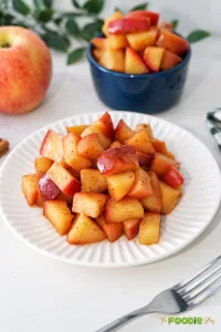Stovetop cinnamon apples with maple syrup served on a white plate